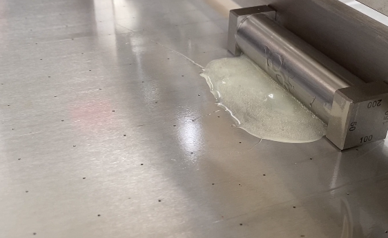 The heated squeegee coater coats the film with UV glue as shown in Figure 2